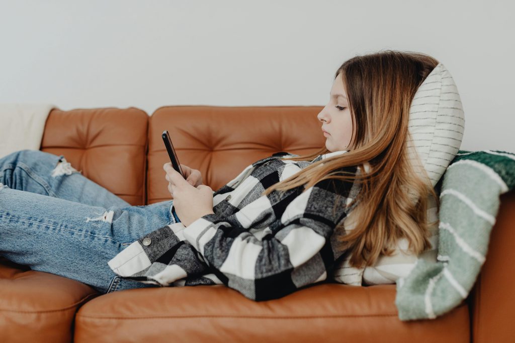 girl using phone on couch